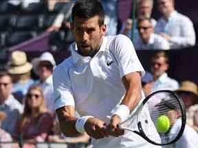 Le Serbe Novak Djokovic rend le ballon au Canadien Felix Auger-Aliassime lors de leur match en simple masculin lors du tournoi The Giorgio Armani Tennis Classic au Hurlingham Club, à Londres, le 22 juin 2022.