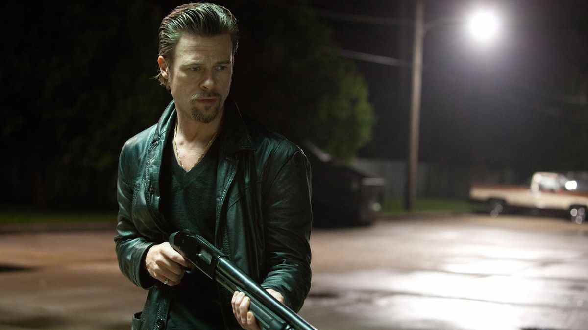 Brad Pitt aux cheveux lisses tenant un fusil de chasse dans Killing Them Softly