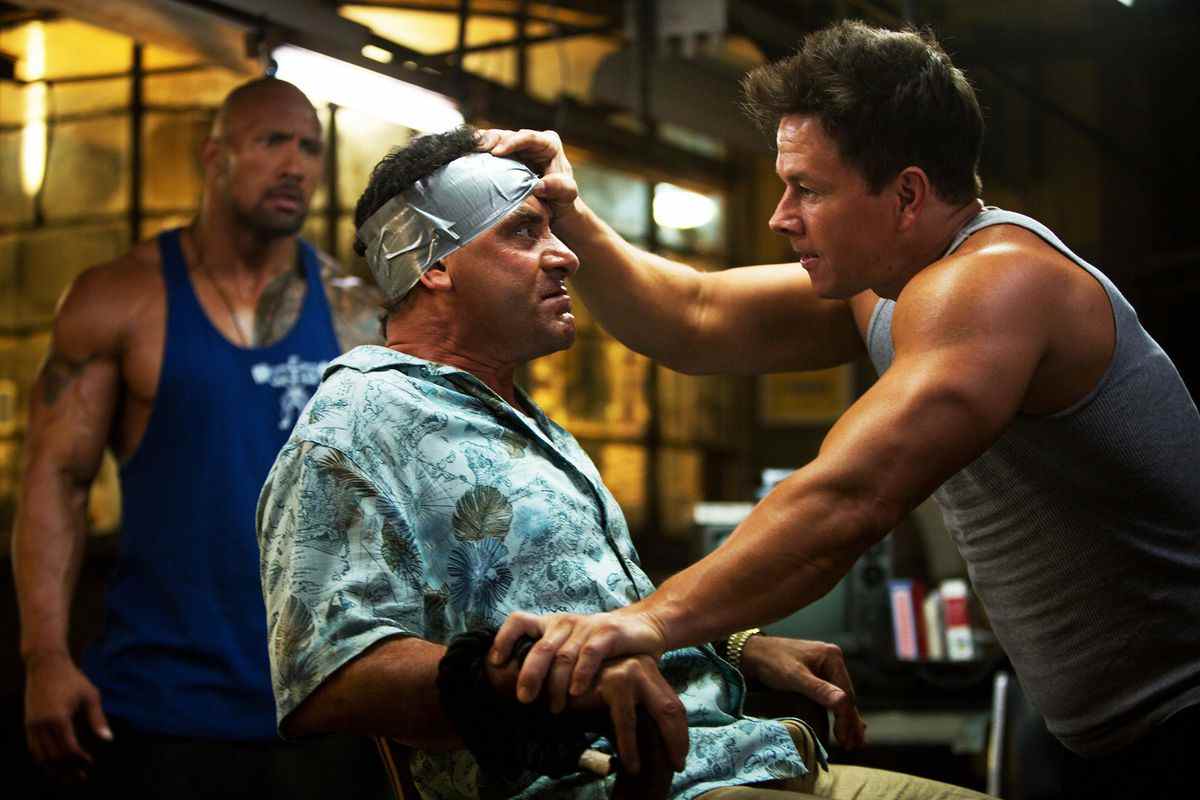 Mark Wahlberg et Dwayne Johnson observent un Tony Shalhoub kidnappé dans Pain &  Gain.