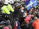 Les manifestants réagissent alors que la police de Toronto monte la charge de l'unité pour se disperser alors que la police prend des mesures pour mettre fin à une manifestation, qui a commencé en opposition aux mandats obligatoires de vaccination contre le COVID-19 et s'est transformée en une manifestation et une occupation antigouvernementales plus larges, à Ottawa, vendredi, 18 février 2022. Le commissaire d'enquête examinant l'utilisation par Ottawa de la Loi sur les mesures d'urgence pour mettre fin à la soi-disant 