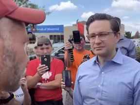 Le candidat à la direction du parti conservateur et député Pierre Poilievre se joint au vétéran James Topp lors de sa marche vers le Monument commémoratif de guerre du Canada à Ottawa, le 30 juin 2022.