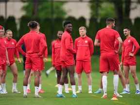 L'attaquant de l'équipe nationale canadienne de soccer masculin Alphonso Davies, au centre, se tient avec ses coéquipiers lors d'une séance d'entraînement pour un match de la Ligue des Nations de la CONCACAF contre Curaçao, à Vancouver, le 7 juin 2022. Canada Soccer dit qu'il a fait une nouvelle offre de compensation à ses hommes et les équipes nationales féminines.