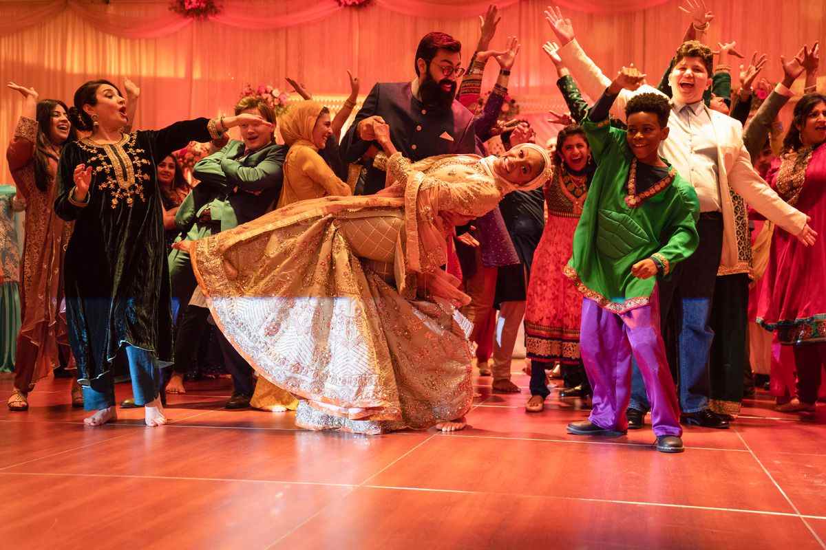 une scène de danse lors d'un grand mariage, avec un jeune enfant dans un hulk salwar kameez