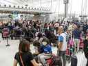 Les voyageurs font la queue au terminal 1 de l'aéroport Pearson de Toronto.