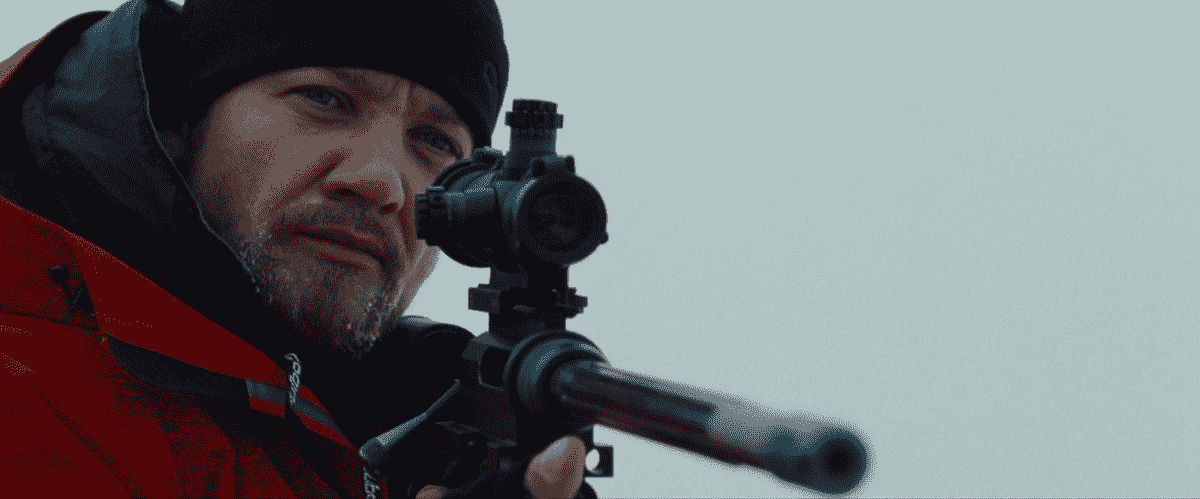 Jeremy Renner, vêtu d'un équipement d'hiver, tient un fusil dans The Bourne Legacy