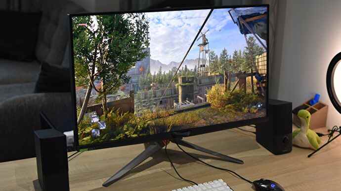 Le moniteur de jeu Asus ROG Swift PG32UQX sur un bureau, exécutant Dying Light 2.