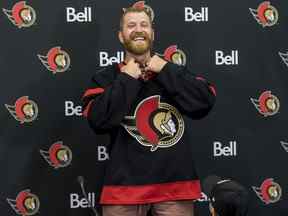 Le nouveau sénateur d'Ottawa Claude Giroux enfile le chandail de l'équipe, sous les yeux de son fils de 3 ans, Gavin, au Centre Canadian Tire.  13 juillet 2022.