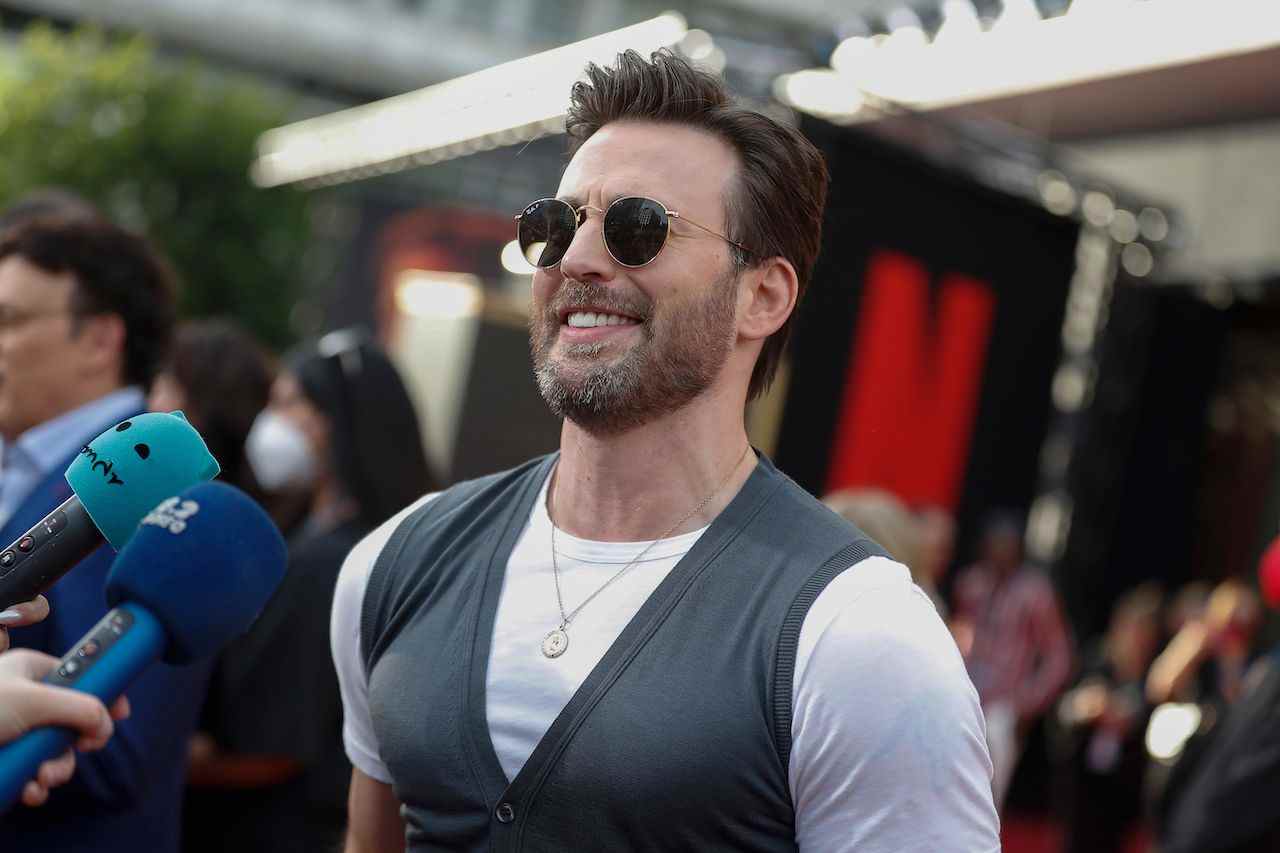 Chris Evans souriant sur le tapis rouge de Grey Man