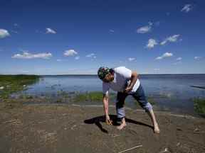 Joseph Zoe, qui a voyagé des Territoires du Nord-Ouest, laisse une offrande de tabac et d'huile au Lac Ste.  Site de pèlerinage d'Anne près d'Alberta Beach le mercredi 20 juillet 2022. Les équipes continuent de travailler sur le site de pèlerinage avant la visite du pape François.  David Bloom/Postmédia