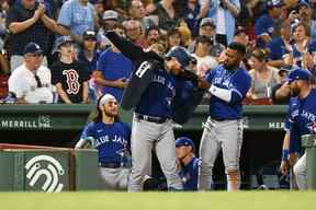 Teoscar Hernandez, n ° 37 des Blue Jays de Toronto, place une veste sur Danny Jansen, n ° 9, après que Jansen a frappé un circuit de deux points contre les Red Sox de Boston lors de la sixième manche au Fenway Park le 22 juillet 2022 à Boston, Massachusetts.