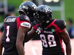 Le receveur large du Rouge et Noir d'Ottawa Darvin Adams (1) célèbre son touché contre les Alouettes de Montréal avec son coéquipier Shaq Johnson (88) lors de la première mi-temps de la LCF à Ottawa le jeudi 21 juillet 2022.