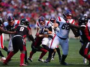 Le quart-arrière des Alouettes de Montréal Trevor Harris (7) franchit la ligne de mêlée lors de la première mi-temps de la LCF contre le Rouge et Noir d'Ottawa à Ottawa le jeudi 21 juillet 2022.