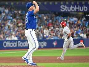 Le lanceur de relève des Blue Jays de Toronto, Trevor Richards, se prépare pour son prochain lancer alors que le joueur de premier but des Cardinals de St. Louis, Albert Pujols, fait le tour des buts après avoir réussi un circuit de trois points en cinquième manche au Rogers Centre de Toronto, le 27 juillet 2022.