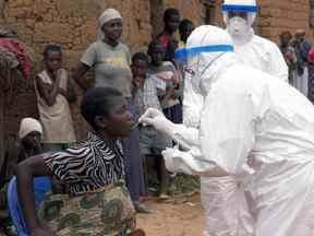 Le docteur Mark Katz, membre de l'Organisation mondiale de la santé (OMS), prélève un échantillon oral sur la patiente Feliciana suspectée d'avoir la fièvre hémorragique de Marburg à Kinguangua, près d'Uige.  La grand-mère, la sœur et l'ex-mari de Feliciana sont morts de la fièvre hémorragique de Marburg.  La jeune femme a été testée négative après avoir été transportée à l'hôpital provincial d'Uige pour observation.