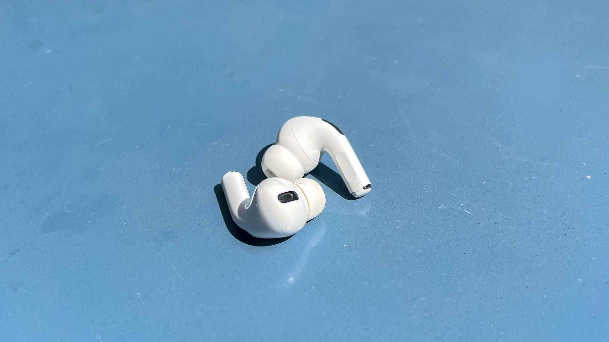 Les AirPods Pro, posés sur une table bleue