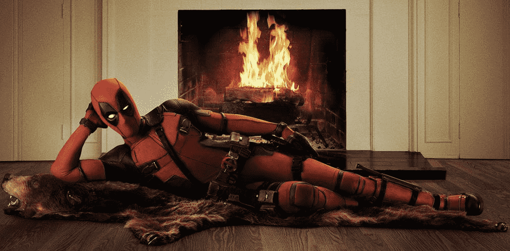 Deadpool de Ryan Reynolds s'allonge coquettement sur un tapis d'ours devant un feu crépitant. 