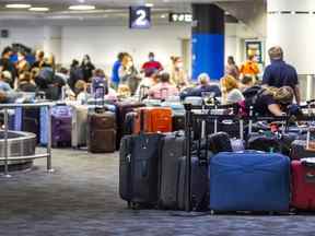 Des personnes recherchent leurs sacs parmi les bagages non réclamés à l'aéroport international Pearson de Toronto le 5 juillet 2022.