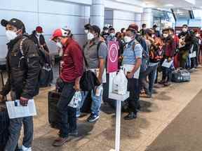 Des voyageurs frustrés font la queue à l'aéroport international Pierre-Elliott-Trudeau de Montréal le 29 juin, au milieu des pénuries de main-d'œuvre et des ralentissements.