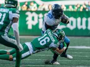 Le demi offensif des Argonauts de Toronto Andrew Harris (33 ans) dirige le ballon alors que le demi défensif des Roughriders de la Saskatchewan Amari Henderson le plaque pendant la première moitié de l'action de football de la LCF à Regina, le dimanche 24 juillet 2022.