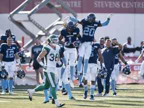 Shaq Richardson (1) des Argonauts de Toronto célèbre son interception avec son coéquipier Tarvarus McFadden (20) devant Jayden Dalke des Roughriders de la Saskatchewan lors des dernières minutes de l'action de la LCF à l'Université Acadia de Wolfville, en Nouvelle-Écosse, le samedi 16 juillet 2022.