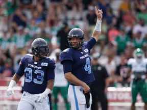 Le quart-arrière des Argonauts de Toronto McLeod Bethel-Thompson, à droite, signale un appel devant son coéquipier Andrew Harris qui cherche à passer pendant la première moitié de l'action de la LCF contre les Roughriders de la Saskatchewan à l'Université Acadia de Wolfville, en Nouvelle-Écosse, le samedi 16 juillet 2022.