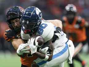 Ben Hladik des Lions de la Colombie-Britannique (à gauche) s'attaque à DaVaris Daniels des Argonauts de Toronto lors de la deuxième moitié de l'action de football de la LCF à Vancouver, en Colombie-Britannique, le samedi 25 juin 2022.