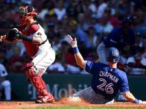 Le joueur de troisième but des Blue Jays de Toronto, Matt Chapman, glisse en toute sécurité à domicile en marquant un point devant le receveur des Red Sox de Boston, Christian Vazquez, lors de la troisième manche au Fenway Park hier.  USA AUJOURD'HUI SPORTS