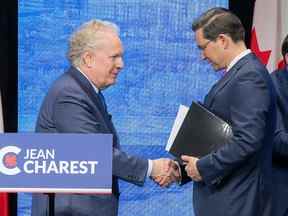 Les candidats à la direction du parti conservateur Jean Charest, à gauche, et Pierre Poilievre participent à un débat à la direction à Edmonton le 11 mai.