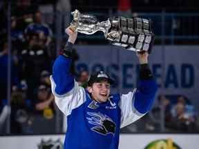 Le capitaine des Sea Dogs de Saint John, Vincent Sevigny, soulève le trophée de la Coupe Memorial après une victoire de 6-3 contre les Bulldogs de Hamilton lors de la finale à l'aréna Harbour Station de Saint John, au Nouveau-Brunswick, le 29 juin 2022.