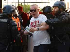 Football football - finale de la Ligue des Champions - Liverpool / Real Madrid - Stade de France, Saint-Denis près de Paris, France - 28 mai 2022 UN fan est tenu par un policier et un steward à l'intérieur du stade par les tourniquets car le match est retardé .