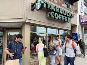 Les gens se pressent autour d'un café Starbucks pour utiliser son wifi gratuit sur le réseau Bell, lors d'une panne majeure des réseaux mobiles et Internet de Rogers Communications.