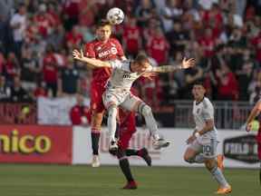 L'attaquant du Toronto FC Jesus Jimenez saute pour le ballon avec l'attaquant des San Jose Earthquakes Benji Kikanovic au cours de la première mi-temps au BMO Field.