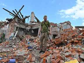 Un militaire ukrainien inspecte les ruines d'un bâtiment détruit après une frappe de missile près de Kharkiv le 5 juillet 2022, au milieu de l'invasion russe de l'Ukraine.