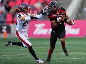 Le quart-arrière du Rouge et Noir d'Ottawa Caleb Evans est poursuivi par le demi défensif des Alouettes de Montréal Marc-Antoine Dequoy (24 ans) au cours de la première demie.