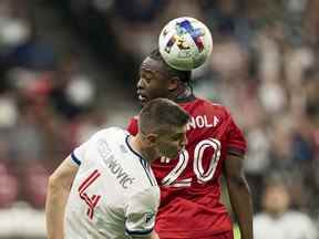 Ayo Akinola du Toronto FC passe le ballon devant Ranko Veselinovic du Vancouver Whitecaps FC lors de la seconde moitié de la finale du Championnat canadien 2022 au BC Place le 26 juillet 2022 à Vancouver, en Colombie-Britannique.