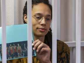 La star de la WNBA et double médaillée d'or olympique Brittney Griner tient une photo de joueurs du récent match des étoiles portant son numéro, assis dans une cage dans une salle d'audience avant une audience devant le tribunal de district de Khimki, juste à l'extérieur de Moscou, Russie , vendredi 15 juillet 2022.