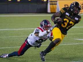 Lawrence Woods des Tiger-Cats a déjoué un tacle du secondeur des Alouettes Tyrice Beverette lors de la première mi-temps à Hamilton jeudi soir.