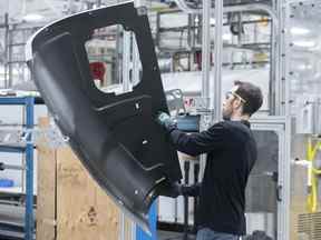 Un travailleur inspecte la porte d'un hélicoptère dans une usine de fabrication de Bell Helicopter Textron Canada à Mirabel, au Québec.