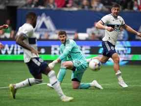 Le gardien de but du Toronto FC Alex Bono, au centre, regarde Tosaint Ricketts, des Whitecaps de Vancouver, à l'avant gauche, marquer après avoir reçu une passe de Lucas Cavallini, à l'arrière droit, lors de la seconde moitié d'un match de soccer de la MLS à Vancouver, en Colombie-Britannique, le dimanche 8 mai. 2022.