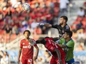 Le gardien de but du Toronto FC Quentin Westberg (16) fait un arrêt contre l'attaquant des Seattle Sounders Fredy Montero (12) au cours de la première mi-temps au BMO Field.