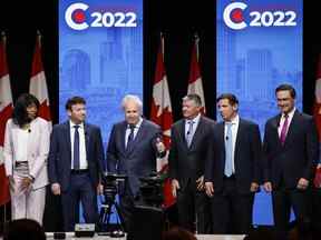 Les candidats, de gauche à droite, Leslyn Lewis, Roman Baber, Jean Charest, Scott Aitchison, Patrick Brown et Pierre Poilievre se tiennent sur scène après le débat à la direction du Parti conservateur du Canada en anglais à Edmonton, le 11 mai 2022.