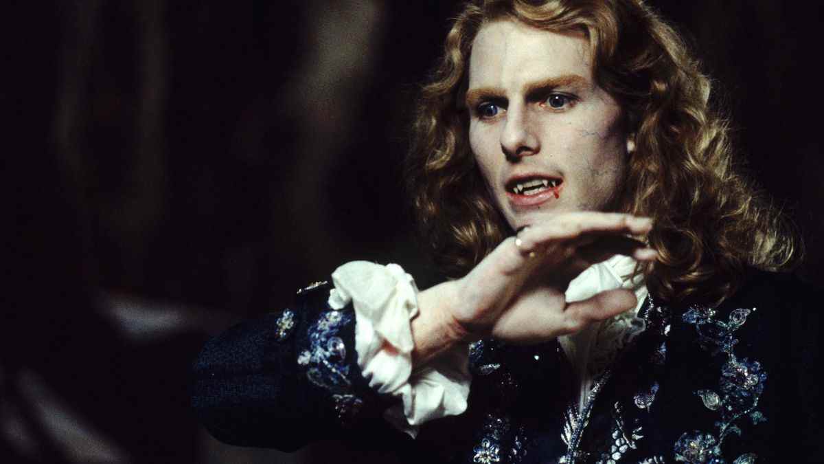 Tom Cruise dans le rôle de Lestat dans Interview With the Vampire, avec de longs cheveux blonds bouclés et du sang coulant de ses crocs