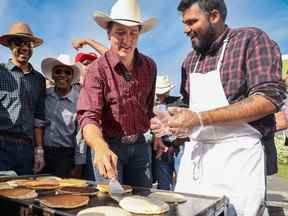 Le premier ministre Justin Trudeau retourne des crêpes lors du petit-déjeuner du député George Chahal au Calgary Stampede au Genesis Centre de Calgary le dimanche 10 juillet 2022.