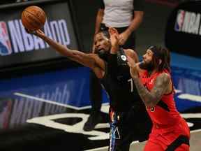 L'attaquant des Brooklyn Nets Kevin Durant tente de garder le ballon dans les limites contre l'attaquant des Raptors de Toronto DeAndre 'Bembry le 5 février 2021.