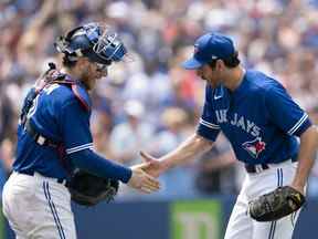 Le plus proche des Blue Jays Jordan Romano (à droite) célèbre la victoire avec le receveur Danny Jansen (à gauche) contre les Royals à la fin du match au Rogers Centre de Toronto, le dimanche 17 juillet 2022.