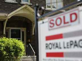 L'enseigne d'un agent immobilier à l'extérieur d'une maison qui a été vendue à Toronto.