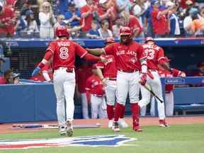 Le joueur de deuxième but des Blue Jays de Toronto Cavan Biggio marque un point et célèbre avec le joueur de premier but des Blue Jays de Toronto Vladimir Guerrero Jr. contre les Rays de Tampa Bay lors de la troisième manche au Rogers Centre le 1er juillet 2022.