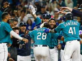 Le joueur de troisième but des Mariners de Seattle, Eugenio Suarez (28 ans), célèbre avec ses coéquipiers après avoir frappé un home run de trois points contre les Blue Jays de Toronto lors de la onzième manche au T-Mobile Park.