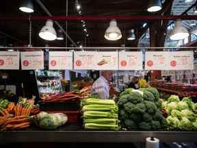 Les gens achètent des produits au marché de Granville Island à Vancouver, le mercredi 20 juillet 2022. Alors que le coût de la vie augmente au rythme le plus rapide depuis des décennies, les Canadiens qui ont du mal à mettre de la nourriture sur la table se tournent vers les organismes communautaires pour obtenir de l'aide.