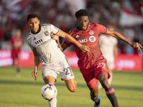 Le défenseur des tremblements de terre de San Jose Marcos Lopez (27 ans) se bat pour le ballon avec l'attaquant du Toronto FC Deandre Kerr au cours de la première mi-temps au BMO Field samedi soir.